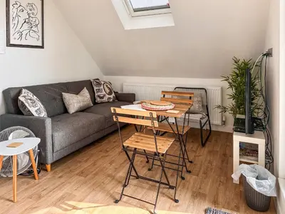a living room with a couch and a table at Secretseaview in West Mersea