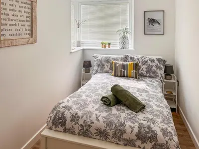a bedroom with a bed with a gray and white comforter at Secretseaview in West Mersea