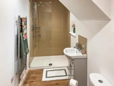 a white bathroom with a sink and a shower at Secretseaview in West Mersea