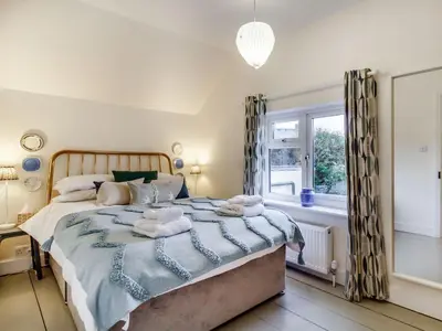 a bedroom with a large bed and a window at The Yellow Cottage On The Hill in Framlingham