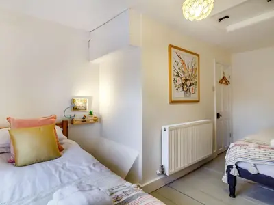 a bedroom with a bed with a yellow pillow on it at The Yellow Cottage On The Hill in Framlingham