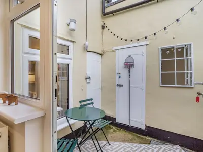 a patio with a table next to a building at The Yellow Cottage On The Hill in Framlingham