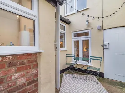 a chair outside of a house with a door at The Yellow Cottage On The Hill in Framlingham