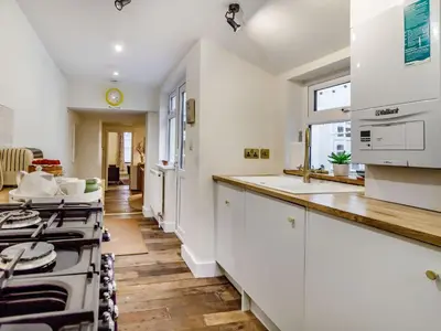 a kitchen with white cabinets and a stove at The Yellow Cottage On The Hill in Framlingham