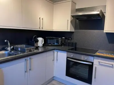 a kitchen with white cabinets and a sink and a stove at Pedlars Rest in Swaffham