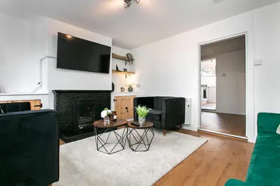 a living room with a fireplace and a tv at Mill Dam Lake House in Saint Osyth