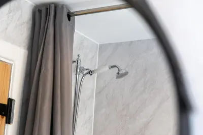 a shower in a bathroom with a mirror at Mill Dam Lake House in Saint Osyth