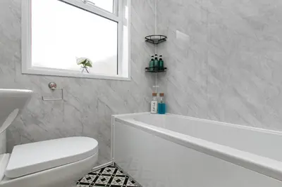 a bathroom with a tub and a toilet and a window at Mill Dam Lake House in Saint Osyth