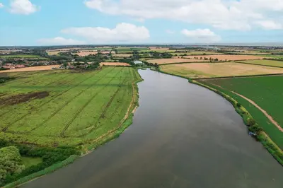 an aerial view of a river in a field at Mill Dam Lake House in Saint Osyth