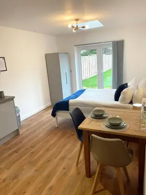 a bedroom with a bed and a table with chairs at Cambridge Studios and Suites by Tas Accommodations in Cambridge