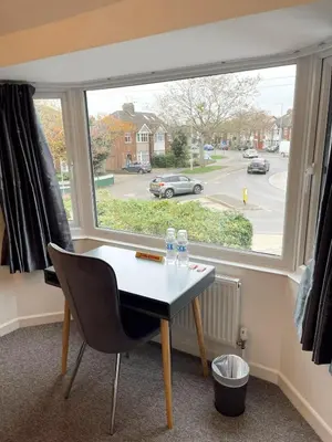 a table and a chair in front of a window at Cambridge Studios and Suites by Tas Accommodations in Cambridge