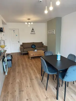 a living room with a table and chairs and a couch at Cambridge Studios and Suites by Tas Accommodations in Cambridge
