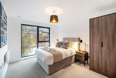 a bedroom with a large bed and a large window at Tailored Stays - Central Cambridge, Lacon House in Cambridge