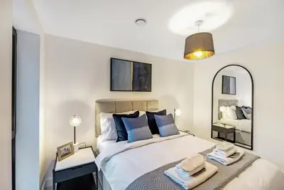 a bedroom with a large bed and a mirror at Tailored Stays - Central Cambridge, Lacon House in Cambridge