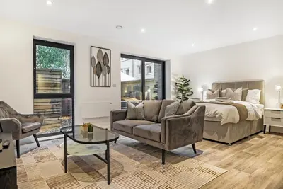 a bedroom with a bed and a couch and a table at Tailored Stays - Central Cambridge, Lacon House in Cambridge