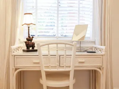 a white desk with a computer and a lamp on it at Tower End Cottage in Woodbridge