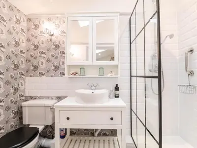 a white bathroom with a sink and a shower at Tower End Cottage in Woodbridge
