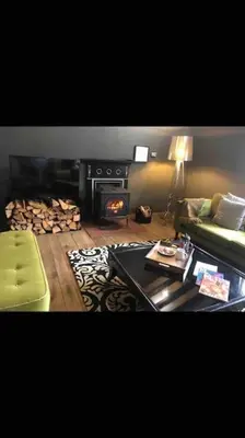 a living room with a couch and a fire place at The Old Mill, 7 storey,, dog friendly outdoor pool & bbq in Stoke Ferry