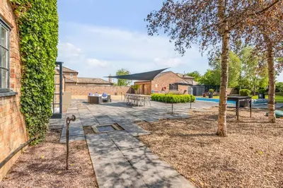 a garden with a patio and a tree at The Old Mill, 7 storey,, dog friendly outdoor pool & bbq in Stoke Ferry