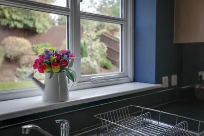 a vase filled with flowers sitting on a window sill at Elizabeth Townhouse Braintree in Bocking Churchstreet