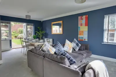 a living room with blue walls and couches at Elizabeth Townhouse Braintree in Bocking Churchstreet