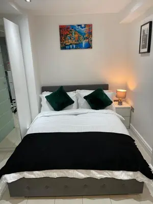 a bedroom with a large bed with green pillows at Modern 1 Bedroom Holiday Apartment in Southminster in Southminster