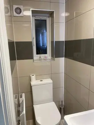 a bathroom with a toilet and a sink and a window at Modern 1 Bedroom Holiday Apartment in Southminster in Southminster