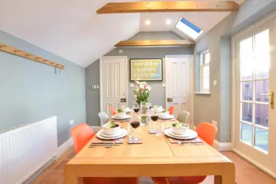 a dining room with a wooden table and orange chairs at 11 Crabbe Street, Aldeburgh in Aldeburgh