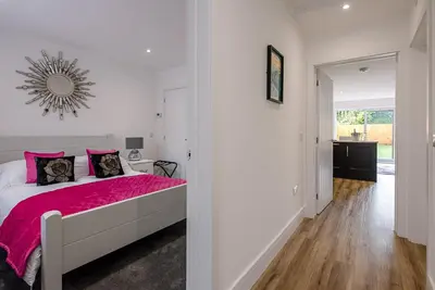 a bedroom with a bed with a pink blanket at 4 Eureka Waldringfield in Woodbridge