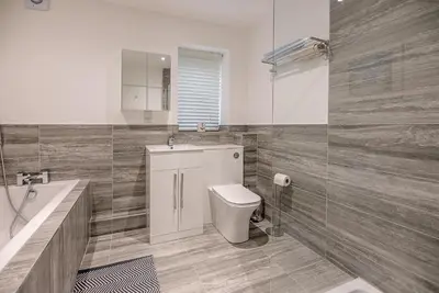 a bathroom with a toilet and a sink and a tub at 4 Eureka Waldringfield in Woodbridge