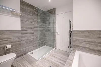 a bathroom with a shower and a toilet and a sink at 4 Eureka Waldringfield in Woodbridge