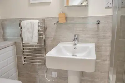 a bathroom with a white sink and a towel rack at 3 Bed in Aldeburgh oc-16afaw in Aldeburgh