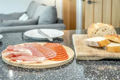 a table topped with a plate of meats and bread at 3 Bed in Aldeburgh oc-16afaw in Aldeburgh