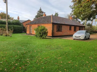 a car parked in front of a brick house at Cosy Rural Barn Conversion 5 Min Drive To Pin Mill 1 BR + sofa bed in Chelmondiston