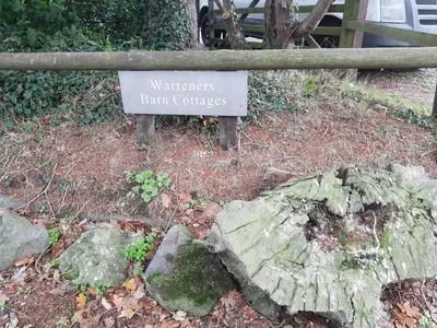 a sign for a garden with a rock at Cosy Rural Barn Conversion 5 Min Drive To Pin Mill 1 BR + sofa bed in Chelmondiston