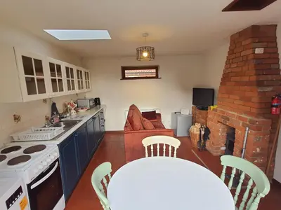 a kitchen with a table and a stove top oven at Cosy Rural Barn Conversion 5 Min Drive To Pin Mill 1 BR + sofa bed in Chelmondiston