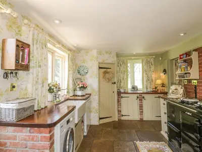 a kitchen with a sink and a stove top oven at Waveney Cottage in Diss