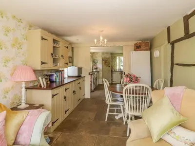 a kitchen and living room with a table and chairs at Waveney Cottage in Diss
