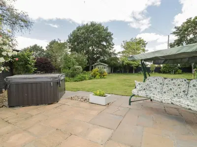 a patio with a couch and a gazebo at Waveney Cottage in Diss