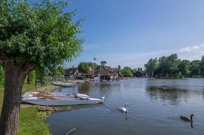 a group of boats sitting on a river with ducks at The Bolthole in Aldeburgh