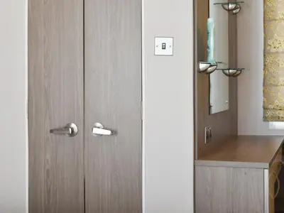 a bathroom with a wooden door with a sink at West Mersea Park in West Mersea