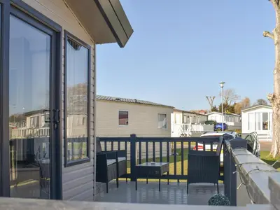 a balcony with chairs and a sliding glass door at West Mersea Park in West Mersea
