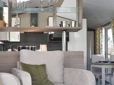 a living room with a chair and a table at West Mersea Park in West Mersea