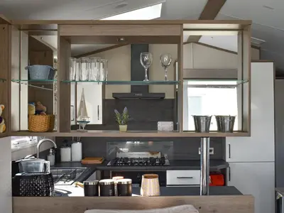 a kitchen with glass shelves and a counter top at West Mersea Park in West Mersea