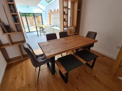 a wooden table and chairs in a room at Bright Beautiful Modern 2 Bed Home Pass The Keys in Cambridge