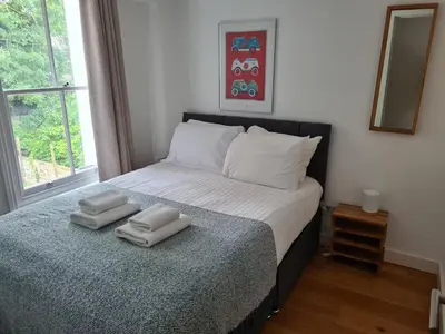 a bedroom with a bed with two towels on it at Bright Beautiful Modern 2 Bed Home Pass The Keys in Cambridge