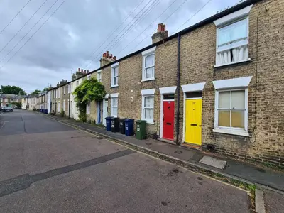 a row of brick houses with colorful doors on a street at Bright Beautiful Modern 2 Bed Home Pass The Keys in Cambridge