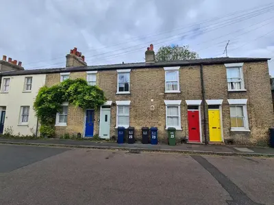 a row of brick houses with colorful doors on a street at Bright Beautiful Modern 2 Bed Home Pass The Keys in Cambridge