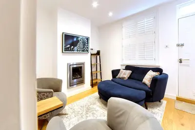 a living room with a blue couch and a fireplace at Bright Beautiful Modern 2 Bed Home Pass The Keys in Cambridge