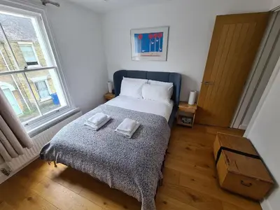 a bedroom with a bed with two towels on it at Bright Beautiful Modern 2 Bed Home Pass The Keys in Cambridge